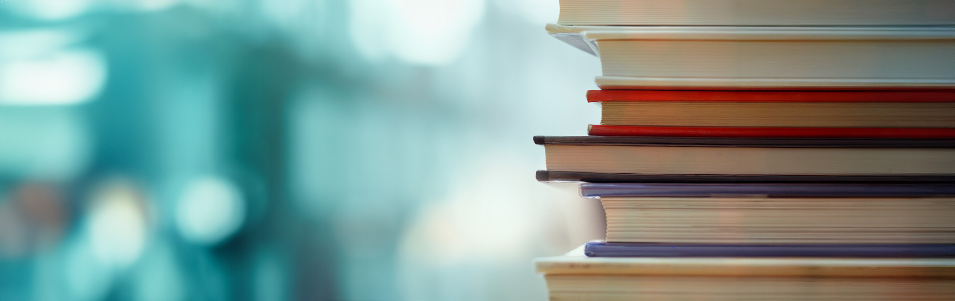 Stacked books with blurred blue background symbol of education